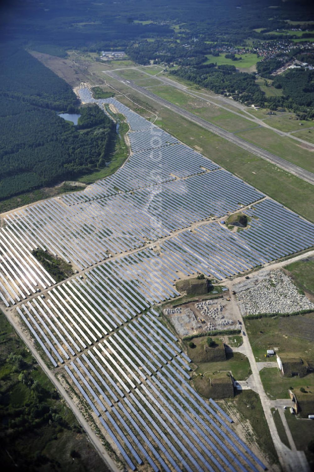 Finow from above - Blick auf die fast fertig montierten Solarfelder des neuen Solarkraftwerk Finow Tower. Die solarhybrid AG errichtet gegenwärtig auf dem ehemaligen Militärflughafen ein Solarstrom-Kraftwerk. Auftraggeber ist die solarinvestra FinowTower GmbH & Co. KG, welche als Fondsgesellschaft durch die interstrom AG und die CH2 Contorhaus Hansestadt Hamburg AG gegründet wurde und das Solarstrom-Kraftwerk betreiben wird. Eigentümer der Immobilie ist die is solarinvestra FT Grundstücks GmbH & Co. KG, eine Tochter von interstrom, die eine Teilfläche des Flughafens von 77 Hektar von der Wirtschafts-Verkehrs-Zentrum GmbH (WZV) erworben hat. View of the almost fully assembled solar fields of the new solar power plant Finow Tower. The hybrid solar AG is currently building on the former military airport, a solar power plant.