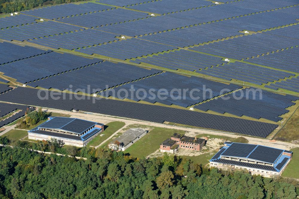 Fürstenwalde/Spree from the bird's eye view: Panel rows of a solar power plant and photovoltaic system on old hangar halls and the former airfield field in Fuerstenwalde/Spree in the state Brandenburg, Germany