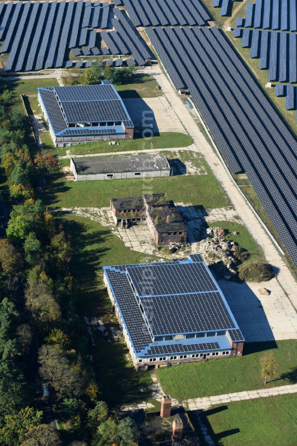 Aerial image Fürstenwalde/Spree - Panel rows of a solar power plant and photovoltaic system on old hangar halls and the former airfield field in Fuerstenwalde/Spree in the state Brandenburg, Germany