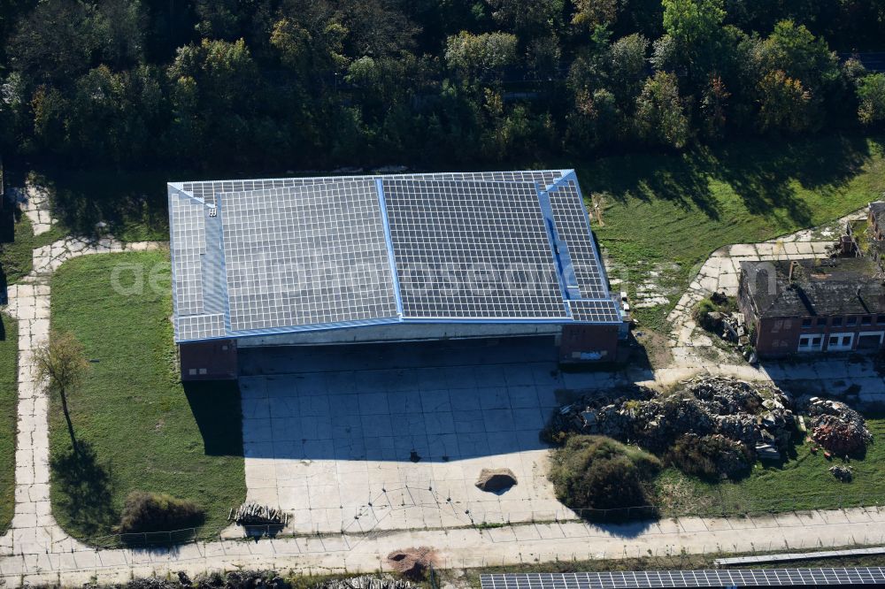 Fürstenwalde/Spree from the bird's eye view: Panel rows of a solar power plant and photovoltaic system on old hangar halls and the former airfield field in Fuerstenwalde/Spree in the state Brandenburg, Germany