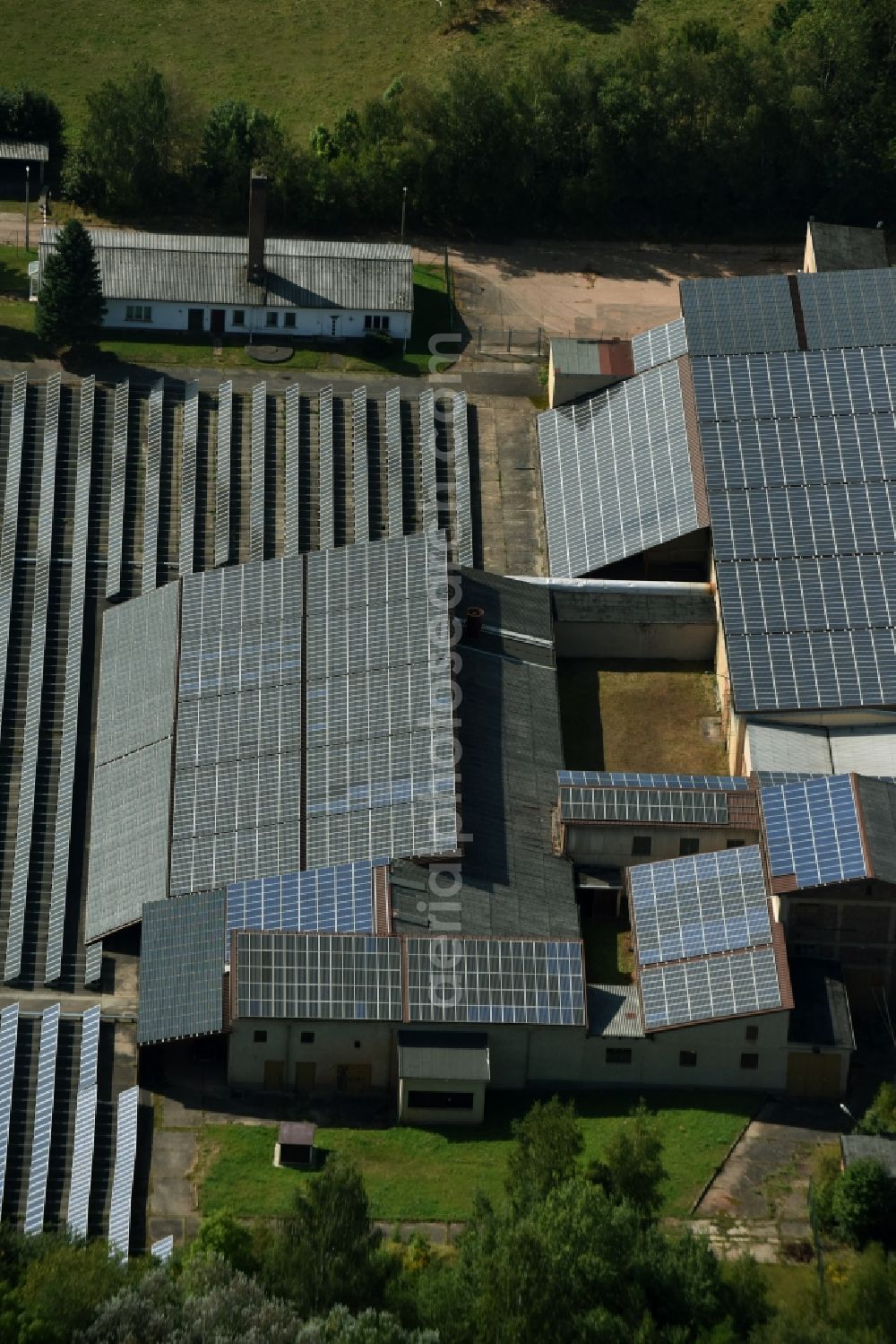 Aerial image Leubnitz - Panel rows of photovoltaic and solar farm or solar power plant on the roof areas at the Wettiner Strasse in Leubnitz in the state Saxony