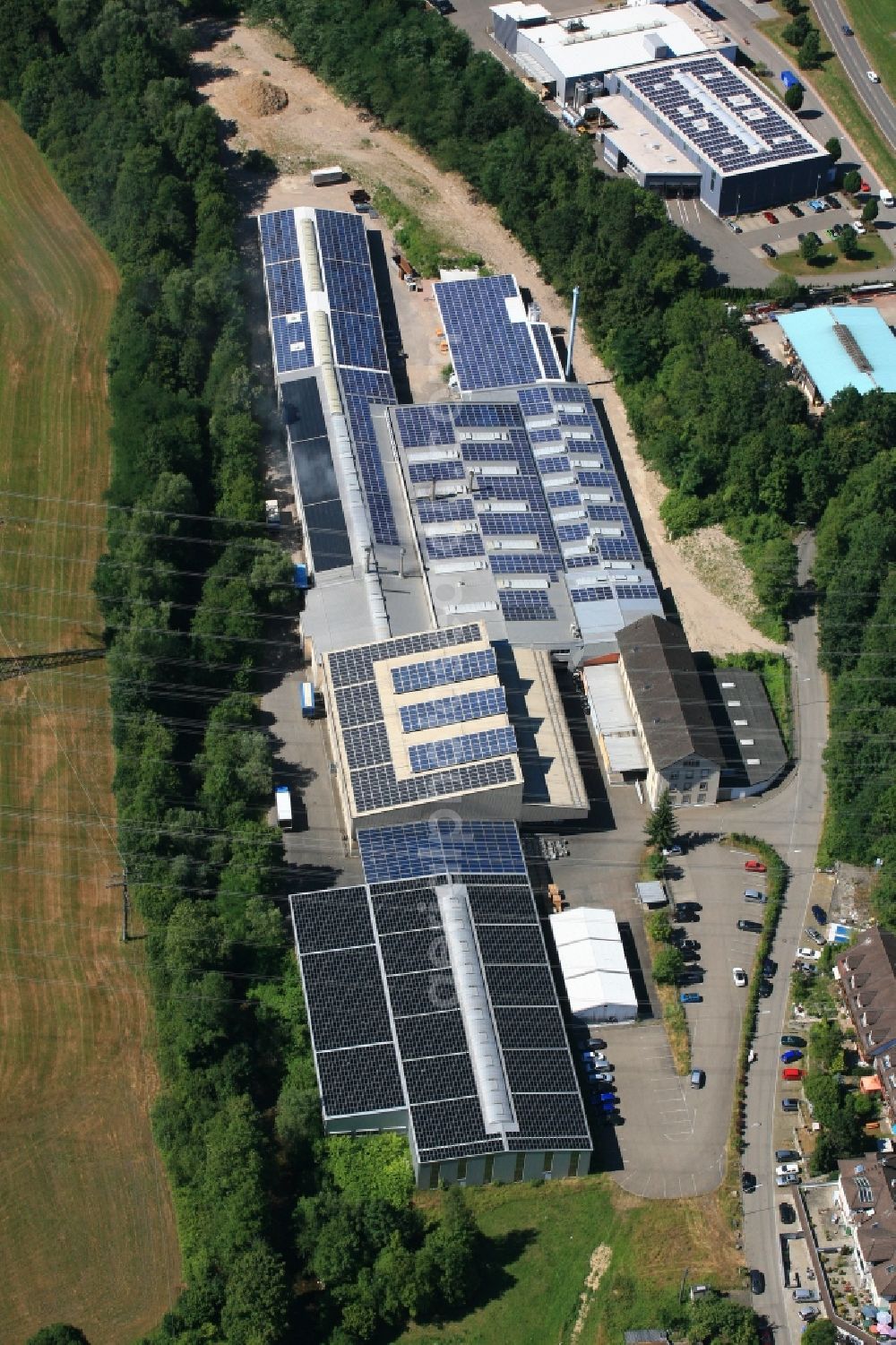 Aerial photograph Wehr - Panel rows of photovoltaic and solar farm or solar power plant on the company's roof and roof areas of the Dreilaendereck GmbH in Wehr in the state Baden-Wuerttemberg