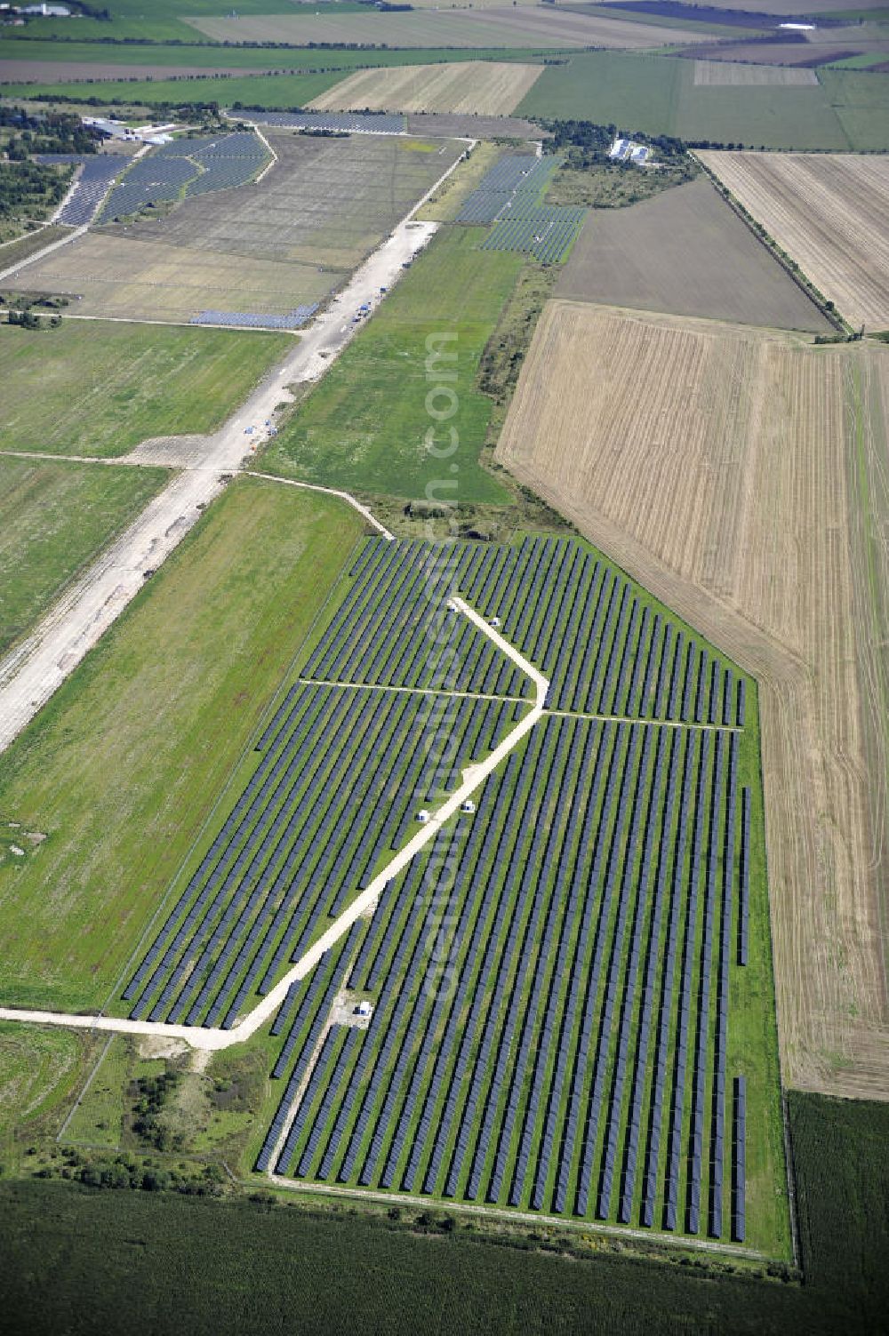 Aerial photograph Köthen - Blick auf den Solarpark auf dem Flugplatz Köthen. Auf einer Fläche von 55 Hektar ist es das bundesweit zweitgrößte Photovoltaik-Kraftwerk und wurde 2008 in Betrieb genommen. Die hochmoderne PV-Anlage besteht aus ca. 200.000 dünnschicht Solarmodulen der Firma First Solar. Betrieben wird das Feld von der juwi solar GmbH. Solar Park at the former airfield Köthen.