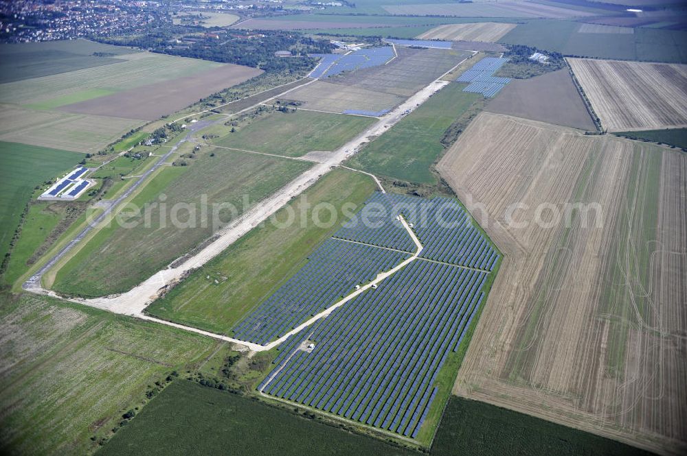 Köthen from above - Blick auf den Solarpark auf dem Flugplatz Köthen. Auf einer Fläche von 55 Hektar ist es das bundesweit zweitgrößte Photovoltaik-Kraftwerk und wurde 2008 in Betrieb genommen. Die hochmoderne PV-Anlage besteht aus ca. 200.000 dünnschicht Solarmodulen der Firma First Solar. Betrieben wird das Feld von der juwi solar GmbH. Solar Park at the former airfield Köthen.