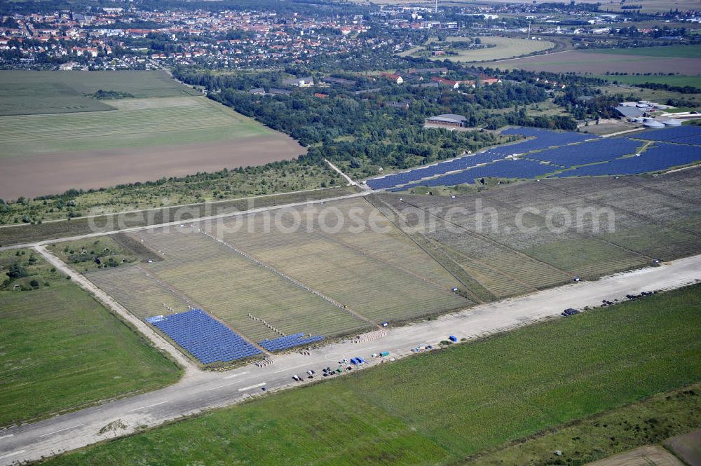 Aerial photograph Köthen - Blick auf den Solarpark auf dem Flugplatz Köthen. Auf einer Fläche von 55 Hektar ist es das bundesweit zweitgrößte Photovoltaik-Kraftwerk und wurde 2008 in Betrieb genommen. Die hochmoderne PV-Anlage besteht aus ca. 200.000 dünnschicht Solarmodulen der Firma First Solar. Betrieben wird das Feld von der juwi solar GmbH. Solar Park at the former airfield Köthen.