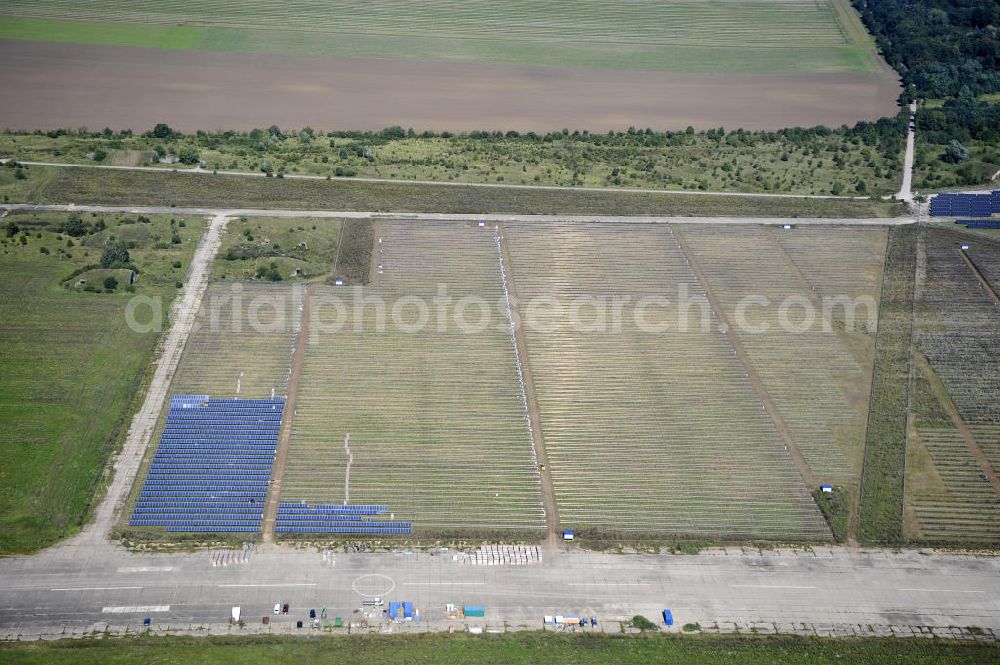 Köthen from above - Blick auf den Solarpark auf dem Flugplatz Köthen. Auf einer Fläche von 55 Hektar ist es das bundesweit zweitgrößte Photovoltaik-Kraftwerk und wurde 2008 in Betrieb genommen. Die hochmoderne PV-Anlage besteht aus ca. 200.000 dünnschicht Solarmodulen der Firma First Solar. Betrieben wird das Feld von der juwi solar GmbH. Solar Park at the former airfield Köthen.