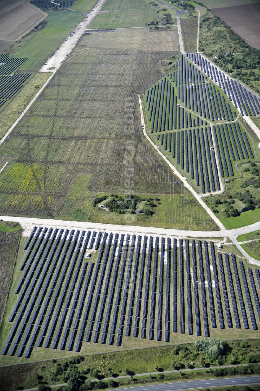 Aerial photograph Köthen - Blick auf den Solarpark auf dem Flugplatz Köthen. Auf einer Fläche von 55 Hektar ist es das bundesweit zweitgrößte Photovoltaik-Kraftwerk und wurde 2008 in Betrieb genommen. Die hochmoderne PV-Anlage besteht aus ca. 200.000 dünnschicht Solarmodulen der Firma First Solar. Betrieben wird das Feld von der juwi solar GmbH. Solar Park at the former airfield Köthen.