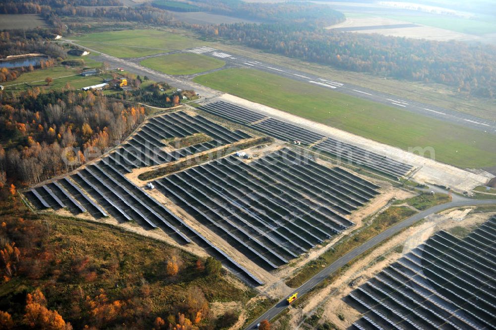 Aerial photograph Falkenberg / Lönnewitz - Die fast abgeschlossenen Bauarbeiten am Solarpark Lönnewitz auf dem Flugplatz Falkenberg / Lönnewitz . Das Solarstrom-Kraftwerk wurde auf ungenutzten Flächen des auf dem ehemaligen Militärflughafen im Rahmen von Konversionsmaßnahmen errichtet. Solar power station in Falkenberg / Lönnewitz Airport.