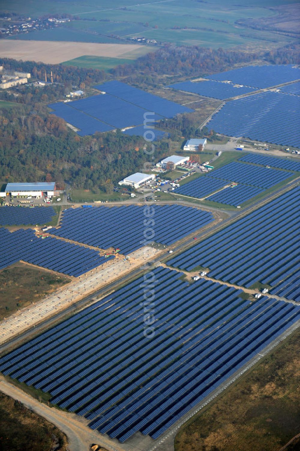 Aerial photograph Falkenberg / Lönnewitz - Die fast abgeschlossenen Bauarbeiten am Solarpark Lönnewitz auf dem Flugplatz Falkenberg / Lönnewitz . Das Solarstrom-Kraftwerk wurde auf ungenutzten Flächen des auf dem ehemaligen Militärflughafen im Rahmen von Konversionsmaßnahmen errichtet. Solar power station in Falkenberg / Lönnewitz Airport.