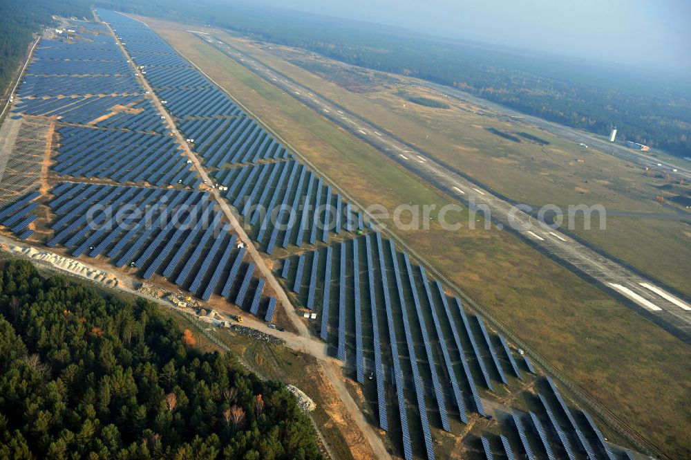 Aerial photograph Drewitz - Die fast abgeschlossenen Bauarbeiten für den Solarpark / die Photovoltaikanlage auf dem Flughafen Drewitz. Das Solarstrom-Kraftwerk Cottbus-Drewitz wurde durch die solarhybrid AG hat als Generalunternehmer und Projektentwickler auf dem ehemaligen Militärflughafen der NVA der DDR errichtet. Solar power station in Cottbus-Drewitz Airport.