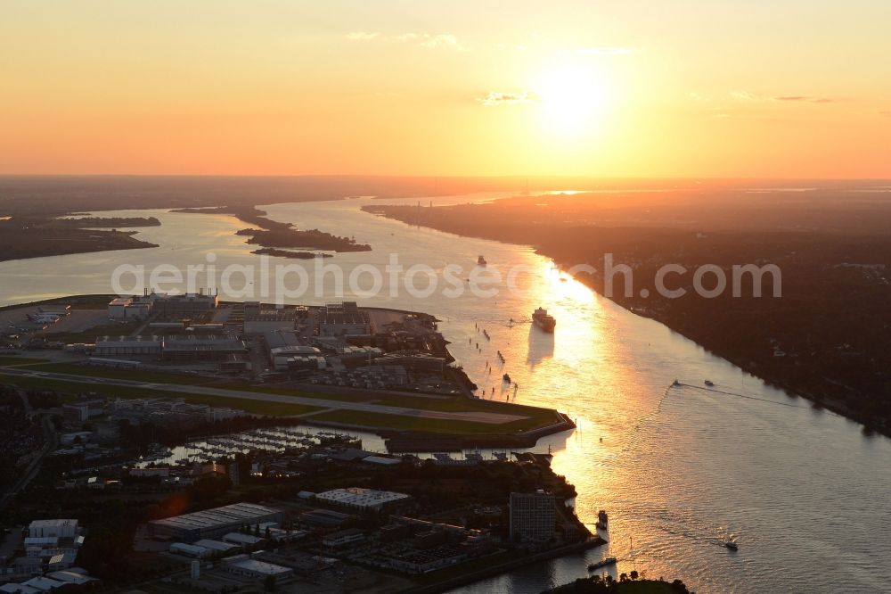 Aerial photograph Hamburg - Sunset over the in-plant airport of Airbus at the river- side of the Elbe which reflects on the water surface in Finkenwerder in Hamburg in Germany