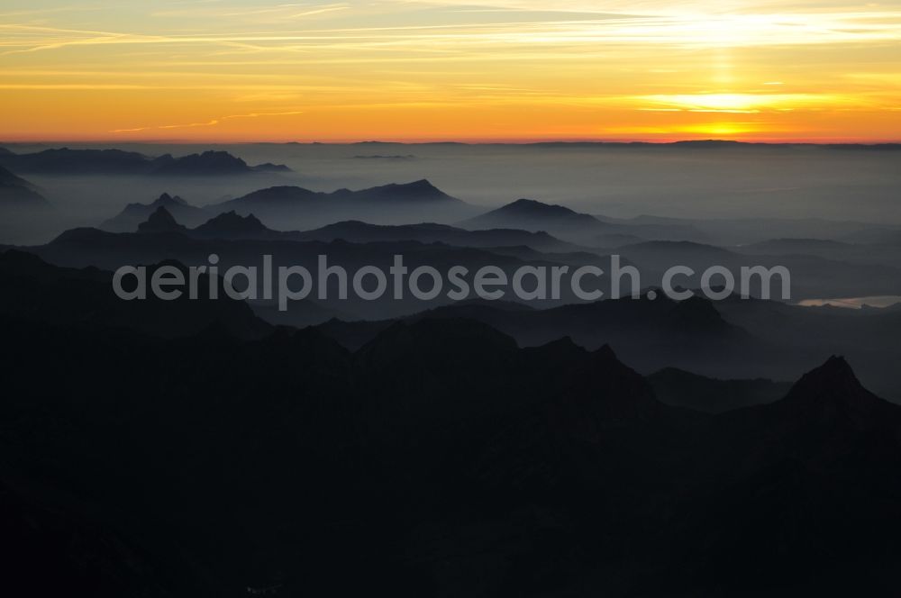 Wallis from above - Sunset with silhouette of the Swiss Alps in the triangle in Valais, Switzerland