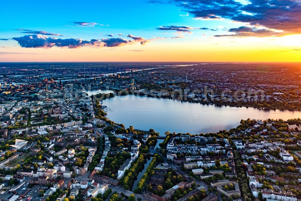 Hamburg from the bird's eye view: Golden yellow colored horizon at sunset over the bank areas at the lake area of the aussenalster in the city center in Hamburg