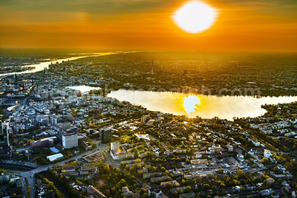 Hamburg from the bird's eye view: Golden yellow colored horizon at sunset over the bank areas at the lake area of the aussenalster in the city center in Hamburg