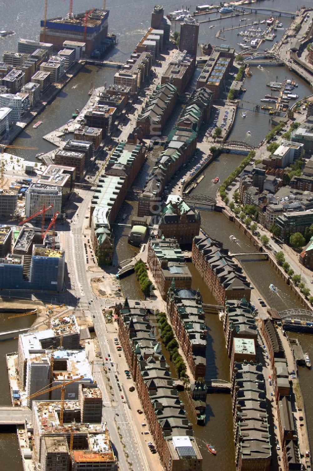 Hamburg from the bird's eye view: Blick auf die historische Speicherstadt an der Baustelle der neu entstehenden Hafen City. Die HafenCity ist ein Hamburger Stadtteil im Bezirk Hamburg-Mitte. Der 155 Hektar große Stadtteil (mit 60 Hektar Nettobauland) soll neben Büroflächen für mehr als 40.000 Arbeitsplätze, die zu einem Teil schon fertiggestellt sind, auch Wohnraum für 12.000 Einwohner in 5.500 Wohnungen bieten und ist damit das größte laufende Vorhaben zur Stadtentwicklung von Hamburg. Allgemeine Informationen: