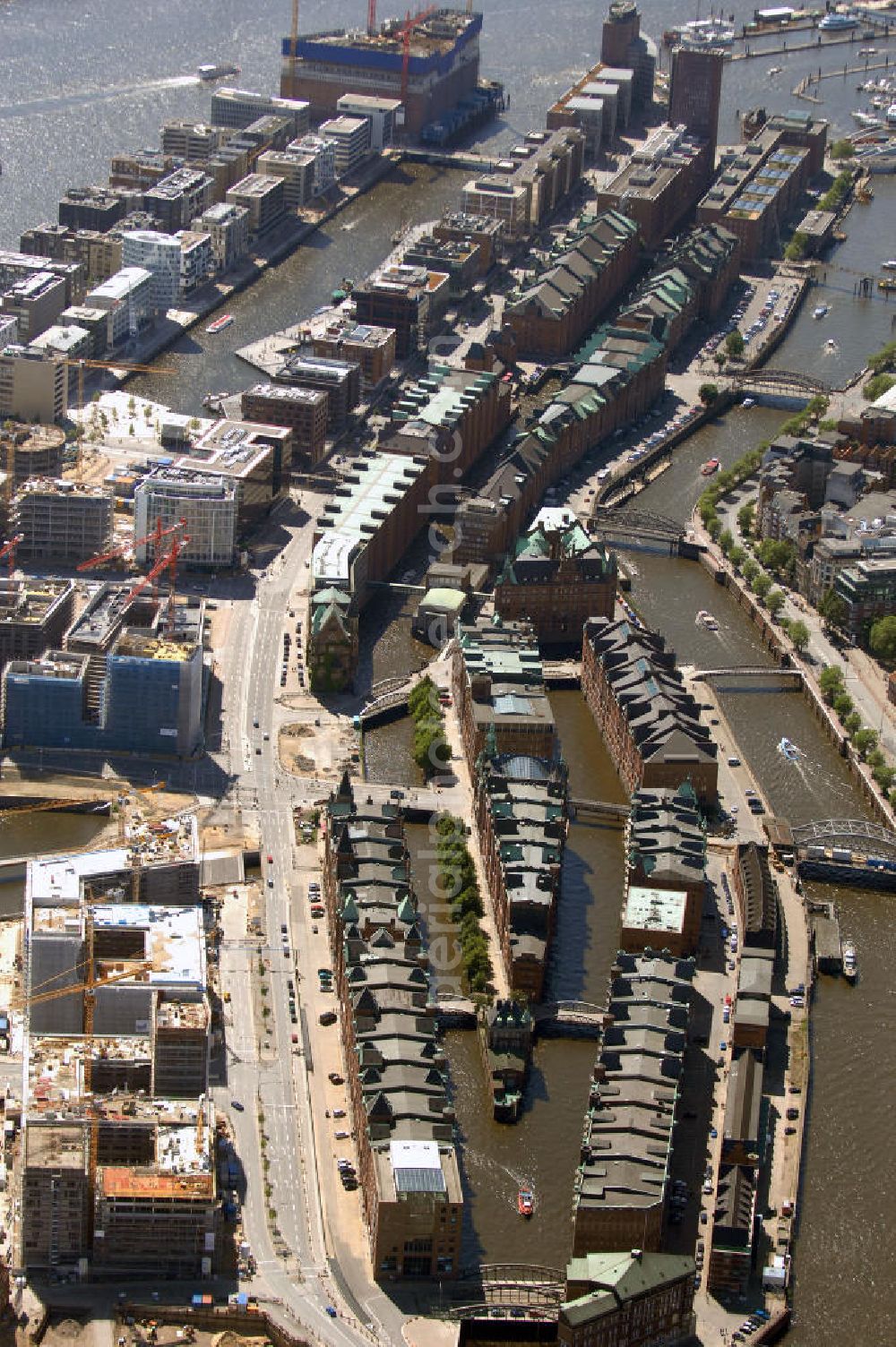 Aerial image Hamburg - Blick auf die historische Speicherstadt an der Baustelle der neu entstehenden Hafen City. Die HafenCity ist ein Hamburger Stadtteil im Bezirk Hamburg-Mitte. Der 155 Hektar große Stadtteil (mit 60 Hektar Nettobauland) soll neben Büroflächen für mehr als 40.000 Arbeitsplätze, die zu einem Teil schon fertiggestellt sind, auch Wohnraum für 12.000 Einwohner in 5.500 Wohnungen bieten und ist damit das größte laufende Vorhaben zur Stadtentwicklung von Hamburg. Allgemeine Informationen: