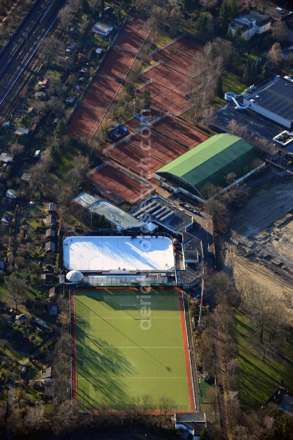 Berlin OT Lankwitz from above - Sportsfacility Leonorenstrasse with the skating rink Eisbahn Lankwitz, the natatorium Stadtbad Lankwitz, a tennis court and a soccerfield in Berlin - Lankwitz. On the construction site at the Leonorenstrasse will be constructed the Leonorengärten apartment houses by the Leonorengärten Wohnbau GmbH, a subsidiary of INTERHOLMES AG