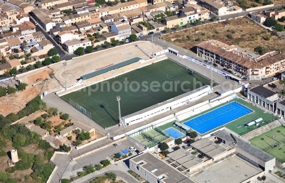 Muro from the bird's eye view: Sports grounds - football pitch, open air swimming pool, tennis court in Muro Mallorca in Balearic Islands, Spain