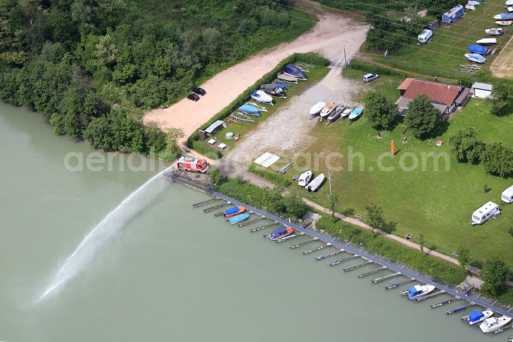 Wehr from above - Pleasure boat marina with docks and moorings on the shore area of the river Rhine in Wehr in the state Baden-Wuerttemberg. Water jet from a fire engine