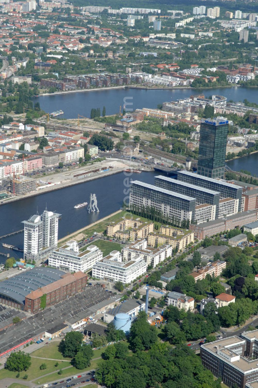 Berlin from the bird's eye view: Blick auf das Spreeufer vor der Oberbaumbrücke in Berlin-Treptow. Mit im Bild die Statue Molecule Man und die Treptowers. Im Vordergrund das Veranstaltungsgelände Arena Berlin am Flutgarben. Kontakt: