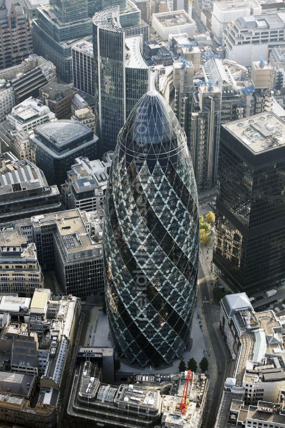 London from above - Blick auf den 30 St Mary Axe, auch The Gherkin (englisch für Gurke) oder Swiss-Re-Tower genannt, er ist ein 180 m hoher Wolkenkratzer im Finanzbezirk der City of London und wurde durch die Stararchitekten Ken Shuttleworth und Sir Norman Foster an der Stelle der durch einen IRA-Anschlag zerstörten Baltic Exchange erstellt. Er ist ein Büroturm des Rückversicherers Swiss Re. View of the 30 St Mary Axe, The Gherkin or Swiss Re Tower, he is a 180 m high skyscraper in the financial district of the City of London.