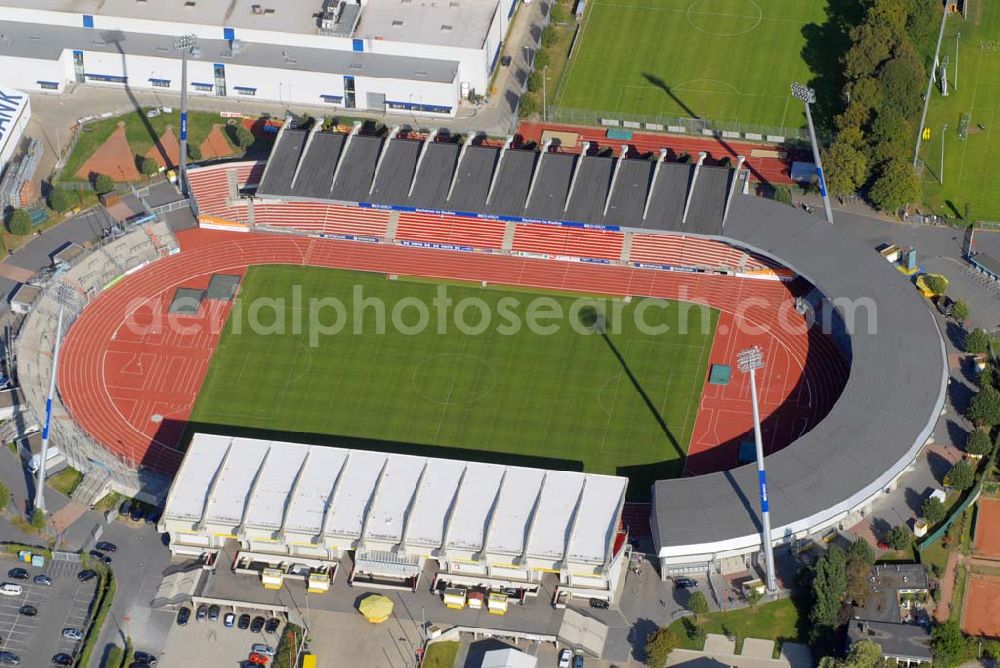 Braunschweig from above - Das Stadion an der Hamburger Straße in Braunschweig hat 23.500 Plätze, davon 10.000 überdachte Sitzplätze und 10.000 überdachte Stehplätze. Es ist das Heimatstadion des Fußball-Zweitligisten Eintracht Braunschweig und des American-Football Bundesligisten Braunschweig Lions. 1995 wurde das Stadion komplett umgebaut. Neue Flutlichtmasten wurden errichtet und die alte Südkurve wurde abgerissen und mit überdachten Stehplätzen wieder aufgebaut. Die Gegengerade, die bisher 10.000 Steh- und 2.000 Sitzplätze bot, wurde zur Sitzplatztribüne. Die Einweihung der Anzeigetafel am 3. November 1996 beendete die Arbeiten zur Grundrenovierung des Stadions.Im Rahmen eines weiteren Umbaus soll das Stadion weiter modernisiert werden. Die Kapazität auf der Haupttribüne wird weiter gesenkt (um etwa 1000 überdachte Sitzplätze), und der gewonnene Platz weicht modernen Businnes-Logen, die eine bessere Vermarktung des Stadions garantieren, aber auch die ansässigen Fussball- bzw. Footballvereine in eine wirtschaftlich stabilere Lage bringen sollen. Im Gegenzug dazu wird ab 2008 die Nordtribüne auf das Niveau der Südkurve ausgebaut sowie die Lücke zwischen der Südkurve und der Haupttribüne geschlossen werden, sodass die Kapazität des Stadions auf etwa 30.000 überdachte Sitz- und Stehplätze steigen wird. Das Stadion soll damit auch den Anforderungen der Fußball-Bundesliga genügen. Den Großteil der Kosten übernimmt die Stadt Braunschweig, jedoch wird bereits nach einem zahlungskräftigen Namenssponsor gesucht.Im Stadion finden auch viele Konzerte und Leichtathletikwettbewerbe statt.