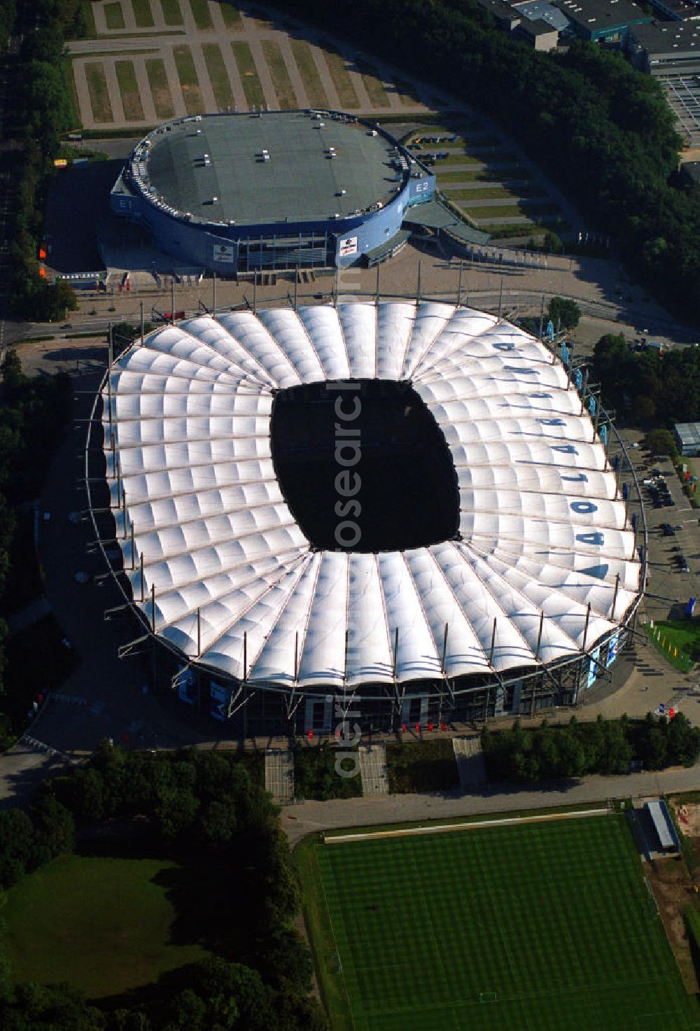 Aerial photograph Hamburg - Blick auf das Stadion HSH Nordbank Arena. Diese ist eine Konzert- und Wettkampfstätte in Hamburg, die überwiegend vom Fußball-Bundesligisten Hamburger SV (HSV) genutzt wird und u.a. Austragungsort der Fußball-Weltmeisterschaft 2006 war. 2010 wird in der HSH Nordbank Arena das Finale des UEFA Cup stattfinden. Bis einschließlich 30. Juni 2001 trug es den Namen Volksparkstadion, bis einschließlich 3. Juli 2007 hieß es AOL Arena. Kontakt: HSH NORDBANK ARENA HAMBURG, HSV-Arena GmbH & CO. KG, Sylvesterallee 7, 22525 Hamburg, Tel. +49 (0)40 415531 10, Fax +49 (0)40 415531 20, e-mail: info@hsv-hshnordbank-arena.de