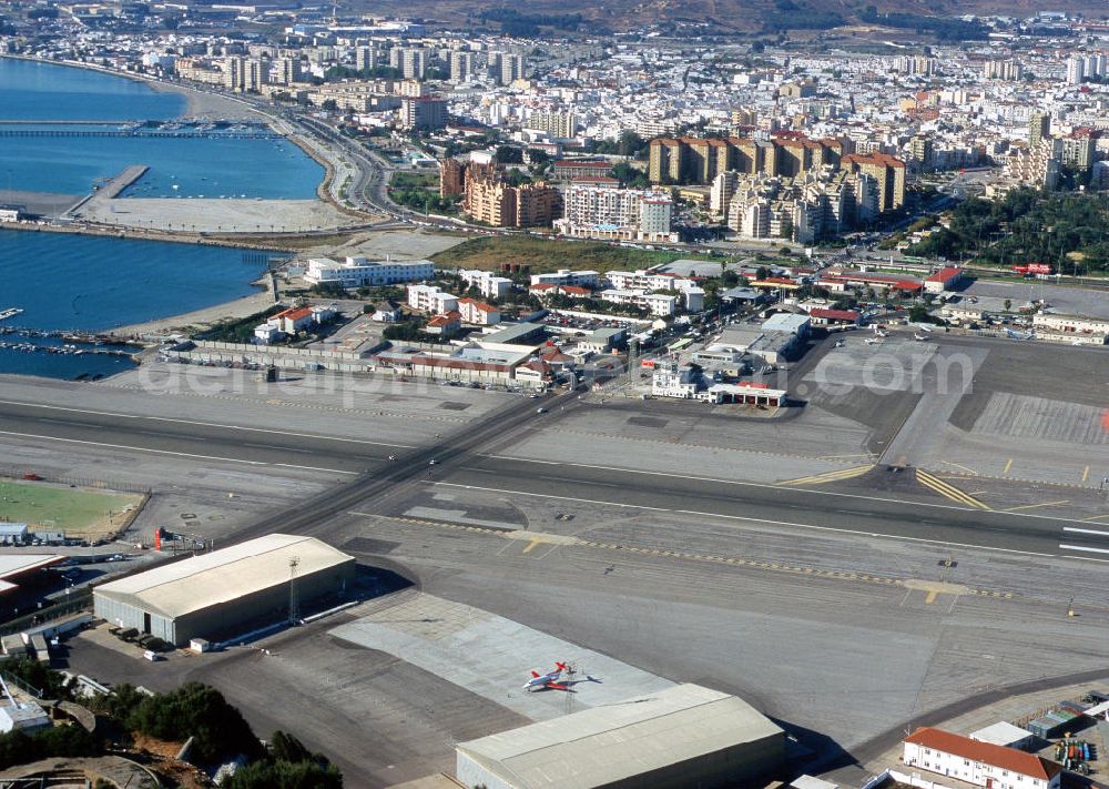 Gibraltar from the bird's eye view: Gribraltar ist ein britisches Überseegebiet an der Iberischen Halbinsel. Die Stadt liegt direkt an der Meerenge Straße von Gibraltar, welche die dichteste Stelle von Europa und Afrika darstellt. Die Verbindungsstraße zwischen Spanien und Gibraltar führt direkt über die Landebahn des Flughafens. Für startende bzw. landende Flugzeuge wird die Straße temporär gesperrt. Gibraltar is a British overseas territory in the Iberian Peninsula. The city is located on the strait of Gibraltar, which is the closest point of Europe and Africa. The communication road between Spain and Gibraltar leads directly on the airport. For taking off and landing aircraft, the road will be temporarily blocked.