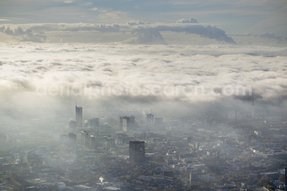 Essen from the bird's eye view: Stadtansicht über die von einer imposanten Nebel- und Wolken- Landschaft eingehüllte Skyline der Essener Innenstadt im Bundesland Nordrhein-Westfalen NRW. Die Herbt Wetter Wolken überziehen die Stadt im Ruhrgebiet mit einer weißen Wolkendecke und umschließen u.a. das Rathaus und den Sitz des Energieversorgers RWE im RWE- Turm am Opernplatz. / Cityscape overlooking the skyline of the Essen city center shrouded by an impressive landscape of fog and clouds in the state North Rhine-Westphalia. The autumn weather clouds cover the Ruhr region city with a thick blanket of clouds and surround among others the townhall and the RWE Tower at Opernplatz.