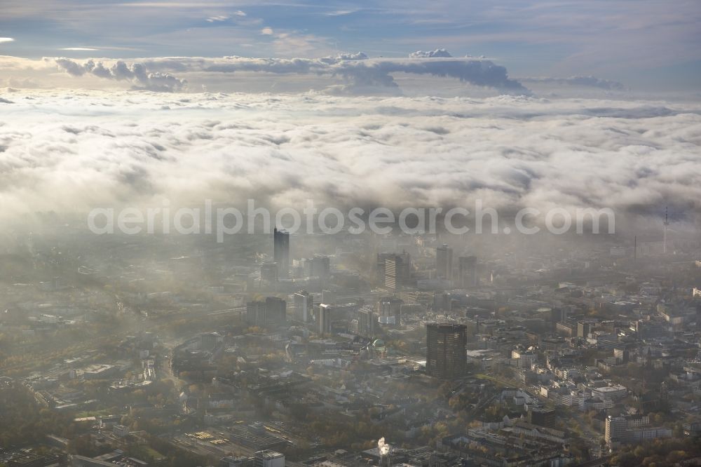 Essen from above - Stadtansicht über die von einer imposanten Nebel- und Wolken- Landschaft eingehüllte Skyline der Essener Innenstadt im Bundesland Nordrhein-Westfalen NRW. Die Herbt Wetter Wolken überziehen die Stadt im Ruhrgebiet mit einer weißen Wolkendecke und umschließen u.a. das Rathaus und den Sitz des Energieversorgers RWE im RWE- Turm am Opernplatz. / Cityscape overlooking the skyline of the Essen city center shrouded by an impressive landscape of fog and clouds in the state North Rhine-Westphalia. The autumn weather clouds cover the Ruhr region city with a thick blanket of clouds and surround among others the townhall and the RWE Tower at Opernplatz.