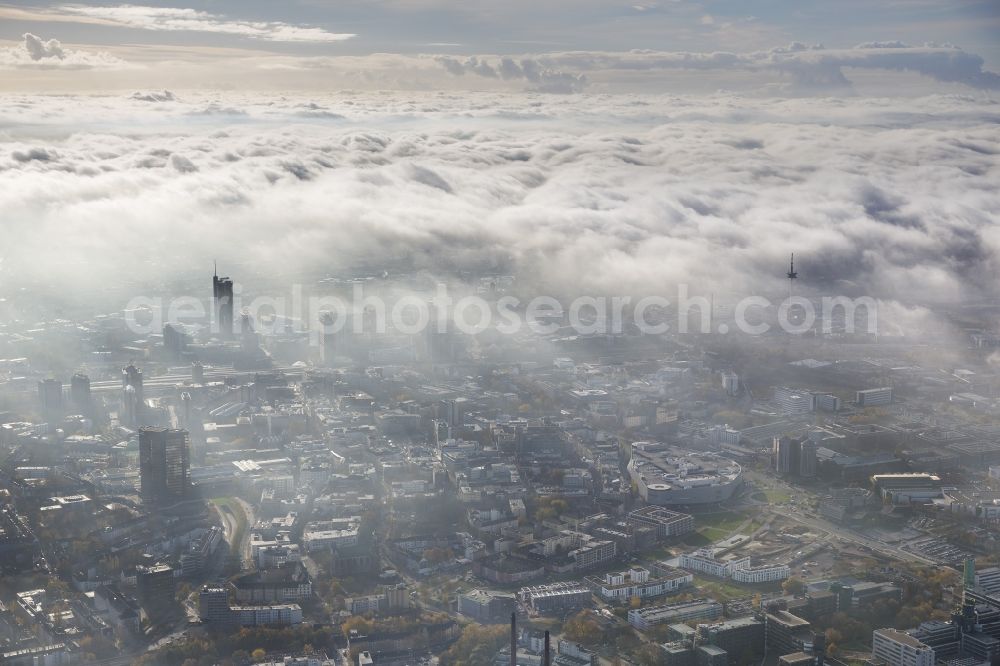 Essen from the bird's eye view: Stadtansicht über die von einer imposanten Nebel- und Wolken- Landschaft eingehüllte Skyline der Essener Innenstadt im Bundesland Nordrhein-Westfalen NRW. Die Herbt Wetter Wolken überziehen die Stadt im Ruhrgebiet mit einer weißen Wolkendecke und umschließen u.a. das Rathaus und den Sitz des Energieversorgers RWE im RWE- Turm am Opernplatz. / Cityscape overlooking the skyline of the Essen city center shrouded by an impressive landscape of fog and clouds in the state North Rhine-Westphalia. The autumn weather clouds cover the Ruhr region city with a thick blanket of clouds and surround among others the townhall and the RWE Tower at Opernplatz.