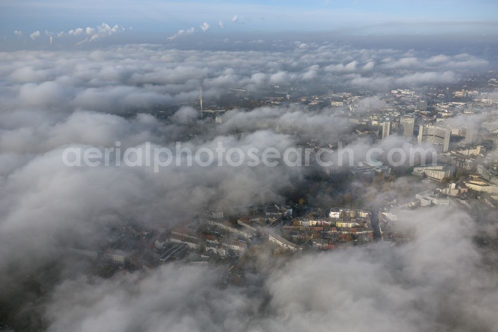 Aerial image Essen - Stadtansicht über die von einer imposanten Nebel- und Wolken- Landschaft eingehüllte Skyline der Essener Innenstadt im Bundesland Nordrhein-Westfalen NRW. Die Herbt Wetter Wolken überziehen die Stadt im Ruhrgebiet mit einer dichten Wolkendecke und umschließen u.a. das Rathaus und den Sitz des Energieversorgers RWE im RWE- Turm am Opernplatz. / Cityscape overlooking the skyline of the Essen city center shrouded by an impressive landscape of fog and clouds in the state North Rhine-Westphalia. The autumn weather clouds cover the Ruhr region city with a thick blanket of clouds and surround among others the townhall and the RWE Tower at Opernplatz.