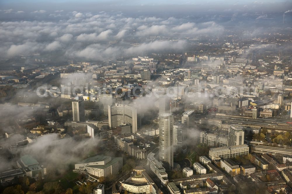 Essen from above - Stadtansicht über die von einer imposanten Nebel- und Wolken- Landschaft eingehüllte Skyline der Essener Innenstadt im Bundesland Nordrhein-Westfalen NRW. Die Herbt Wetter Wolken überziehen die Stadt im Ruhrgebiet mit einer dichten Wolkendecke und umschließen u.a. das Rathaus und den Sitz des Energieversorgers RWE im RWE- Turm am Opernplatz. / Cityscape overlooking the skyline of the Essen city center shrouded by an impressive landscape of fog and clouds in the state North Rhine-Westphalia. The autumn weather clouds cover the Ruhr region city with a thick blanket of clouds and surround among others the townhall and the RWE Tower at Opernplatz.