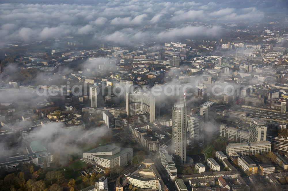 Essen from the bird's eye view: Stadtansicht über die von einer imposanten Nebel- und Wolken- Landschaft eingehüllte Skyline der Essener Innenstadt im Bundesland Nordrhein-Westfalen NRW. Die Herbt Wetter Wolken überziehen die Stadt im Ruhrgebiet mit einer dichten Wolkendecke und umschließen u.a. das Rathaus und den Sitz des Energieversorgers RWE im RWE- Turm am Opernplatz. / Cityscape overlooking the skyline of the Essen city center shrouded by an impressive landscape of fog and clouds in the state North Rhine-Westphalia. The autumn weather clouds cover the Ruhr region city with a thick blanket of clouds and surround among others the townhall and the RWE Tower at Opernplatz.