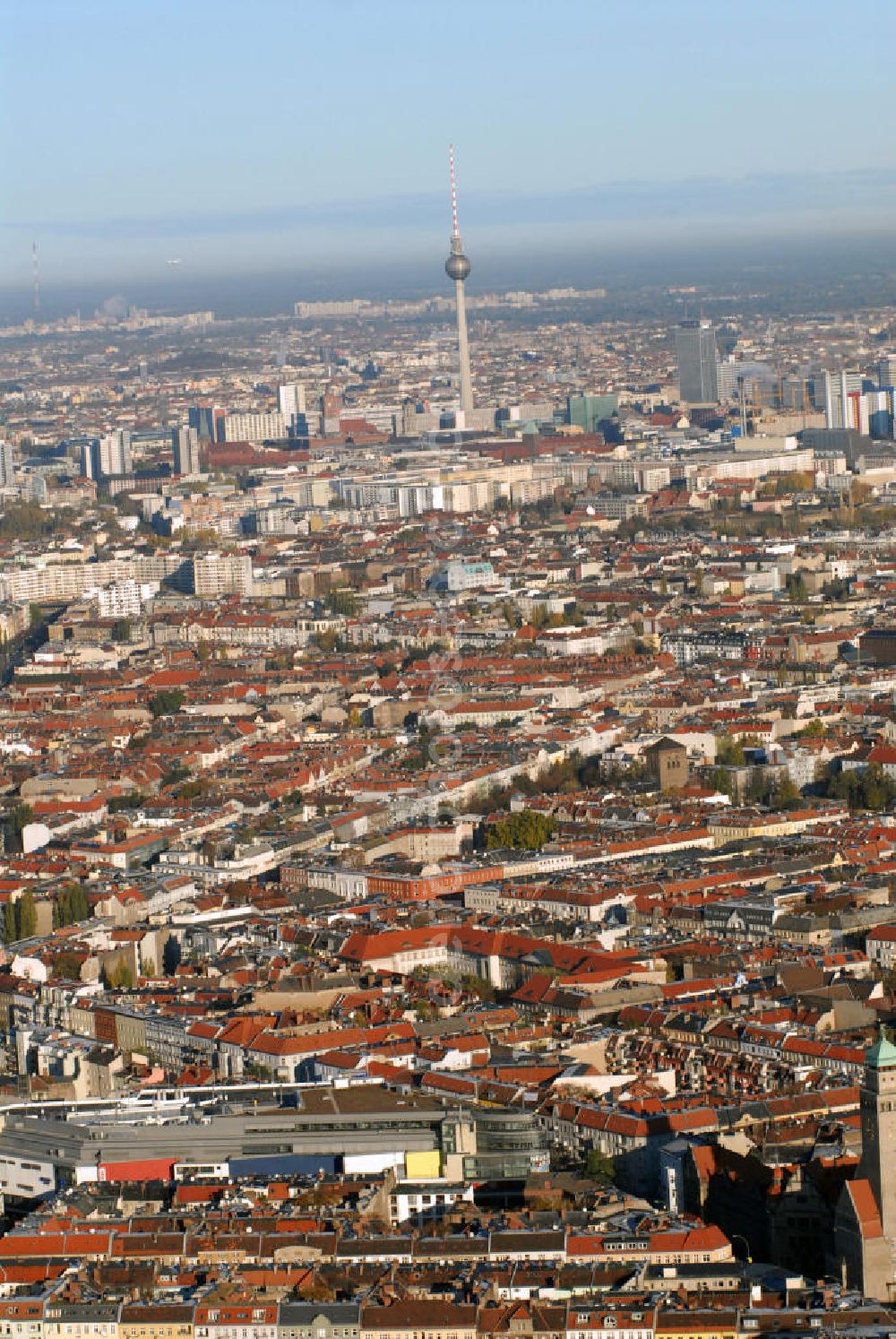 Aerial photograph Berlin - Blick auf die Innenstadt und den Fernsehturm von Berlin. Berlin ist Bundeshauptstadt und Regierungssitz Deutschlands. Als Stadtstaat ist Berlin ein eigenständiges Land und bildet das Zentrum der Metropolregion Berlin/Brandenburg. Berlin ist mit 3,4 Millionen Einwohnern die bevölkerungsreichste und flächengrößte Stadt Deutschlands und nach Einwohnern die zweitgrößte Stadt der Europäischen Union. Der Berliner Fernsehturm ist mit 368 Meter das höchste Bauwerk Deutschlands und das vierthöchste freistehende Bauwerk Europas. Er befindet sich im östlichen Zentrum auf dem Alexanderplatz.