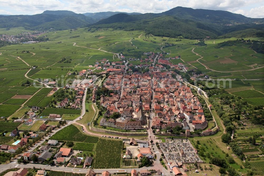 Bergheim from the bird's eye view: Cityscape of the Alsatian community Bergheim Haut-Rhin in France. Bergheim is surrounded by a double city wall with towers and a gate. The municipality in part of the Regional Natural Park of Ballons des Vosges