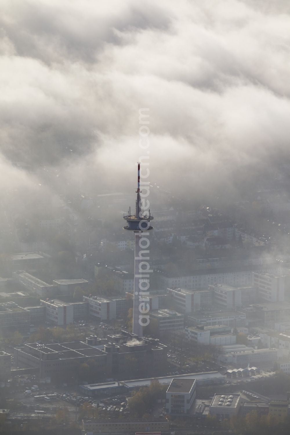 Essen from the bird's eye view: Cityscape with a view of the telecommunication tower coated with fog and an impressive cloud bank over the city center of Essen in the state North Rhine-Westphalia. The autumn weather clouds are surrounding the television tower at its location in the Holsterhausen district and form a thick cover over the Ruhr region city