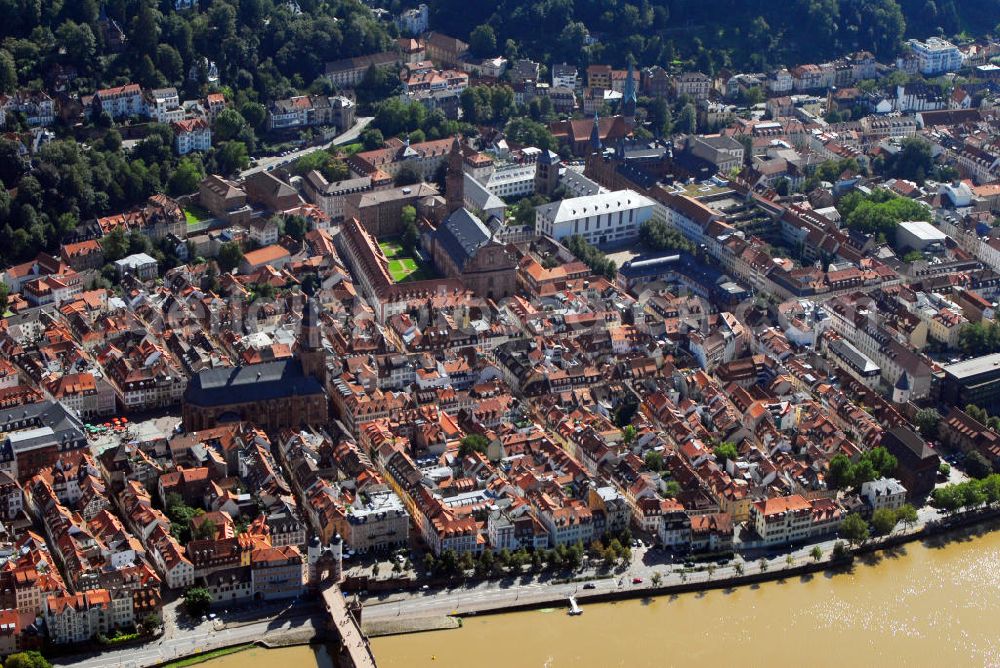 Aerial image Heidelberg - Stadtansicht mit Blick auf die drei Kirchen Heidelbergs. Heidelberg ist eine Großstadt am Neckar im Südwesten Deutschlands. Mit über 140.000 Einwohnern ist Heidelberg die fünftgrößte Stadt Baden-Württembergs. Sie ist kreisfreie Stadt und zugleich Sitz des umliegenden Rhein-Neckar-Kreises. Die Heiliggeistkirche, links am Bildrand, ist die bekannteste Kirche von Heidelberg. Sie steht am Marktplatz mitten im alten Zentrum von Heidelberg, nur unweit vom Heidelberger Schloss entfernt und beherrscht mit ihrer weit über die Dächer ragenden Silhouette das ganze Stadtbild. Die Heiliggeistkirche wurde 1239 zum ersten Mal erwähnt. 1398 wurde der Grundstein für ihre heutige, spätgotische Form gelegt, welche die damalige spätromanische Basilika gleichen Namens ersetzte, die selbst auch nicht der ursprüngliche Bau war. Kontakt: Heiliggeistkirche, Heiliggeiststr. 17, 69117 Heidelberg, Tel.: 06221 21117, http://heiliggeist.ekihd.de. Die Peterskirche, am oberen Bildrand, ist die älteste Kirche der Heidelberger Altstadt. Seit dem Spätmittelalter diente sie vielfach als Universitätskapelle der Universität Heidelberg. Universitätskirche ist sie seit 1896. Vermutlich wurde die Peterskirche sogar vor der Gründung Heidelbergs errichtet. Sie dient als letzte Ruhestätte für etwa 150 Professoren und kurfürstliche Hofleute. Kontakt: Peterskirche, Plöck 70, 69117 Heidelberg-Altstadt, Universitätsprediger Prof. Dr. Helmut Schwier, Tel.: 06221-543326/27, E-Mail: helmut.schwier@pts.uni-heidelberg.de. Unweit der Heiliggeistkirche und der Peterskirche befindet sich auch die Jesuitenkirche (Bildmitte). Sie ist das Wahrzeichen der Gegenreformation in Heidelberg und bildete einst den Mittelpunkt des ehemaligen Jesuitenviertels. Sie ist heute die Hauptkirche der römisch-katholischen Heilig-Geist-Gemeinde. Der Bau der Jesuitenkirche wurde in den Jahren 1712 bis 1723 unter der Leitung von Johann Adam Breuning begonnen. Die Fertigstellung erfolgte jedoch erst 1759 unter dem Architekten des kurpfälzischen Hofes, Franz Wilhelm Rabaliatti. 1793 - 1797 wurde die Jesuitenkirche als Lazarett für Verwundete des ersten Koalitionskrieges genutzt. Kontakt: Jesuitenkirche Heidelberg, Merianstr. 2, 69117 Heidelberg, Tel.: 06221 / 9008-0,