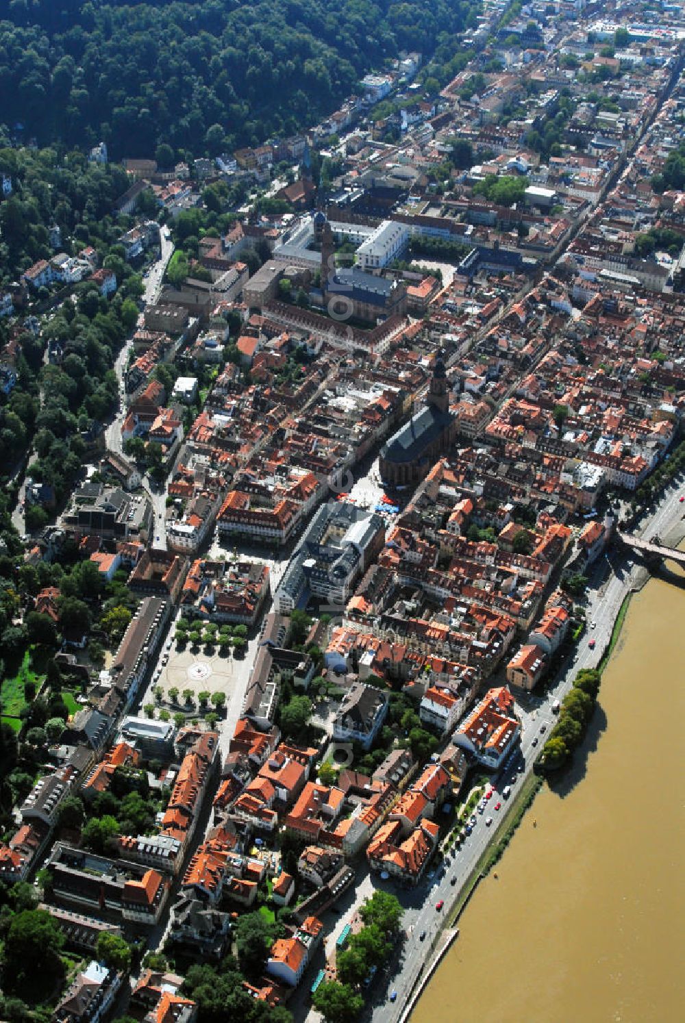 Aerial photograph Heidelberg - Stadtansicht mit Blick auf die drei Kirchen Heidelbergs. Heidelberg ist eine Großstadt am Neckar im Südwesten Deutschlands. Mit über 140.000 Einwohnern ist Heidelberg die fünftgrößte Stadt Baden-Württembergs. Sie ist kreisfreie Stadt und zugleich Sitz des umliegenden Rhein-Neckar-Kreises. Die Heiliggeistkirche (1.v.unten) ist die bekannteste Kirche von Heidelberg. Sie steht am Marktplatz mitten im alten Zentrum von Heidelberg, nur unweit vom Heidelberger Schloss entfernt und beherrscht mit ihrer weit über die Dächer ragenden Silhouette das ganze Stadtbild. Die Heiliggeistkirche wurde 1239 zum ersten Mal erwähnt. 1398 wurde der Grundstein für ihre heutige, spätgotische Form gelegt, welche die damalige spätromanische Basilika gleichen Namens ersetzte, die selbst auch nicht der ursprüngliche Bau war. Kontakt: Heiliggeistkirche, Heiliggeiststr. 17, 69117 Heidelberg, Tel.: 06221 21117, http://heiliggeist.ekihd.de. Die Peterskirche, am oberen Bildrand, ist die älteste Kirche der Heidelberger Altstadt. Seit dem Spätmittelalter diente sie vielfach als Universitätskapelle der Universität Heidelberg. Universitätskirche ist sie seit 1896. Vermutlich wurde die Peterskirche sogar vor der Gründung Heidelbergs errichtet. Sie dient als letzte Ruhestätte für etwa 150 Professoren und kurfürstliche Hofleute. Kontakt: Peterskirche, Plöck 70, 69117 Heidelberg-Altstadt, Universitätsprediger Prof. Dr. Helmut Schwier, Tel.: 06221-543326/27, E-Mail: helmut.schwier@pts.uni-heidelberg.de. Unweit der Heiliggeistkirche und der Peterskirche befindet sich auch die Jesuitenkirche (2.v.unten). Sie ist das Wahrzeichen der Gegenreformation in Heidelberg und bildete einst den Mittelpunkt des ehemaligen Jesuitenviertels. Sie ist heute die Hauptkirche der römisch-katholischen Heilig-Geist-Gemeinde. Der Bau der Jesuitenkirche wurde in den Jahren 1712 bis 1723 unter der Leitung von Johann Adam Breuning begonnen. Die Fertigstellung erfolgte jedoch erst 1759 unter dem Architekten des kurpfälzischen Hofes, Franz Wilhelm Rabaliatti. 1793 - 1797 wurde die Jesuitenkirche als Lazarett für Verwundete des ersten Koalitionskrieges genutzt. Kontakt: Jesuitenkirche Heidelberg, Merianstr. 2, 69117 Heidelberg, Tel.: 06221 / 9008-0,