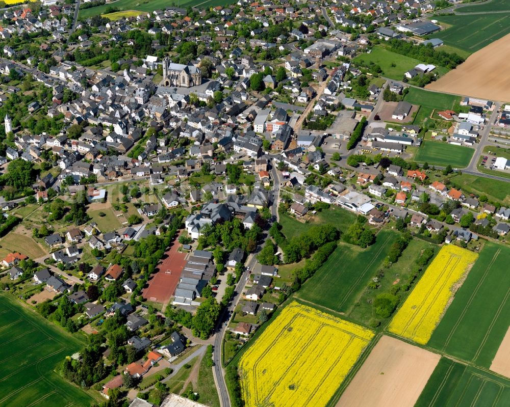 Münstermaifeld from the bird's eye view: View of Muenstermaifeld in the state of Rhineland-Palatinate. The agricultural town is located in the county district of Mayen-Koblenz and surrounded by meadows and rapeseed fields. The official tourist resort is located in the borough of Maifeld is known for its widely visible cathedral which is located in the centre of the town on Muenster Square