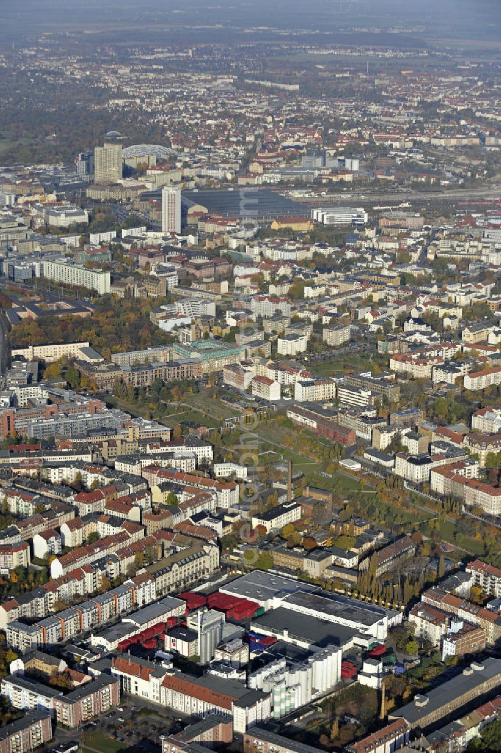 Aerial image Leipzig - Blick über den Stadtteil Reudnitz-Thonberg in Richtung Stadtzentrum und Hauptbahnhof im Herbst. Vorn das Leipziger Brauhaus zu Reudnitz und der Lene-Voigt-Park auf dem Gelände des ehemaligen Eilenburger Bahnhofs. Views over the district Reudnitz-Thonberg to the city center and the main train station.