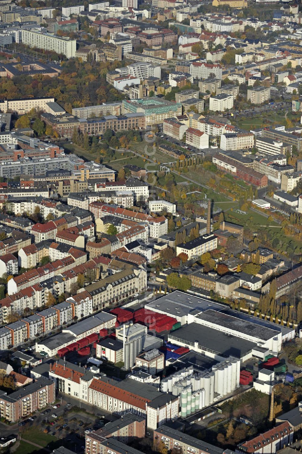 Aerial photograph Leipzig - Blick über den Stadtteil Reudnitz-Thonberg in Richtung Stadtzentrum und Hauptbahnhof im Herbst. Vorn das Leipziger Brauhaus zu Reudnitz und der Lene-Voigt-Park auf dem Gelände des ehemaligen Eilenburger Bahnhofs. Views over the district Reudnitz-Thonberg to the city center and the main train station.