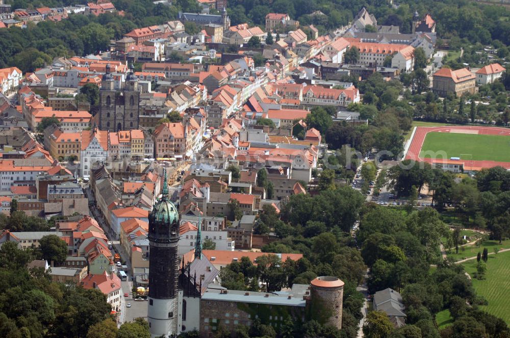 Lutherstadt Wittenberg from above - Blick auf die Wittenberger-Altstadt. Die Lutherstadt Wittenberg zählt zu den kulturell und historisch wichtigsten Städten Europas. Im Bild, die Straßenzüge Wallstraße und Collegienstraße / Jüdenstraße. Hier befinden sich u.a. das Schloss Wittenberg, die Stadtkirche und das Rathaus der Stadt. Die weltberühmte Schlosskirche ist Bestandteil des UNESCO-Weltkulturerbes und schließt das gesamte Objekt von der Nordseite ab. Die Urform der Schlosskirche muss 1496 in solch unzureichendem Zustand gewesen sein, dass nach deren Abriss ein Kirchneubau entstand, der erst 1506 beendet wurde. Berühmtheit erlangte sie, als am 31. Oktober 1517 der bis dahin nahezu unbekannte Wittenberger Augustinermönch und Theologieprofessor Martin Luther seine 95 lateinischen Disputationsthesen verbreitete. Kontakt: Schloss- und Universitätskirche Allerheiligen, Schlossplatz, 06886 Lutherstadt Wittenberg, Tel.: 03491 - 40258