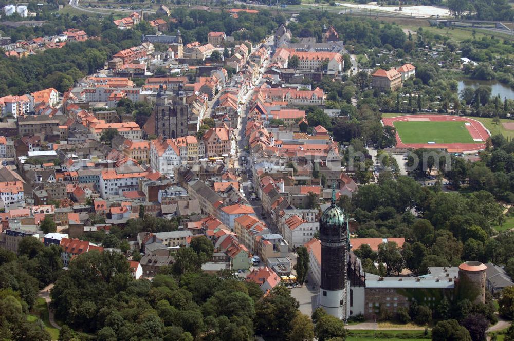 Lutherstadt Wittenberg from the bird's eye view: Blick auf die Wittenberger-Altstadt. Die Lutherstadt Wittenberg zählt zu den kulturell und historisch wichtigsten Städten Europas. Im Bild, die Straßenzüge Wallstraße und Collegienstraße / Jüdenstraße. Hier befinden sich u.a. das Schloss Wittenberg, die Stadtkirche und das Rathaus der Stadt. Die weltberühmte Schlosskirche ist Bestandteil des UNESCO-Weltkulturerbes und schließt das gesamte Objekt von der Nordseite ab. Die Urform der Schlosskirche muss 1496 in solch unzureichendem Zustand gewesen sein, dass nach deren Abriss ein Kirchneubau entstand, der erst 1506 beendet wurde. Berühmtheit erlangte sie, als am 31. Oktober 1517 der bis dahin nahezu unbekannte Wittenberger Augustinermönch und Theologieprofessor Martin Luther seine 95 lateinischen Disputationsthesen verbreitete. Kontakt: Schloss- und Universitätskirche Allerheiligen, Schlossplatz, 06886 Lutherstadt Wittenberg, Tel.: 03491 - 40258