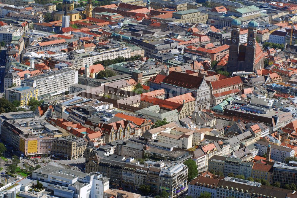 München from above - Stadtansicht München mit Blick auf die Frauenkirche. Die Frauenkirche ist die Kathedralkirche des Erzbischofs von München und Freising und gilt als Wahrzeichen der bayerischen Landeshauptstadt. Der dreischiffige spätgotische Backsteinbau mit umlaufendem Kapellenkranz ist 109 m lang, 40 m breit und 37 m hoch. Die Kirche bietet etwa 20.000 stehenden Menschen Platz, was erstaunlich ist, wenn man bedenkt, dass die Stadt zur Bauzeit im ausgehenden 15. Jh. nur etwa 13.000 Einwohner hatte. Die Grundsteinlegung für die heutige Frauenkirche - die wahrscheinlich bereits einen kleineren Vorgänger hatte, den sie ersetzte - erfolgte im Jahr 1468 durch Herzog Sigismund. Da man aus Kostengründen einen gemauerten Backsteinbau errichten wollte, statt auf teure Steinmetzarbeiten zurück zu greifen, wurde die Leitung der Bauarbeiten Jörg von Halspach, einem Maurermeister, übertragen. Im Jahr 1494 wurde die Frauenkirche geweiht. Im Zweiten Weltkrieg schwer beschädigt, wurde die Kirche in der Nachkriegszeit wieder aufgebaut, dabei erhielt sie ihr heutiges eher nüchternes, aber dennoch gewaltiges und markantes Äußeres. Von der ursprünglichen Ausstattung sind noch einige mittelalterliche Skulpturen und die mittelalterlichen Glasgemälde der Chorfenster erhalten geblieben. Mit ihrer herrlichen zentralen Lage inmitten einer großzügigen Fußgängerzone, die zwischen Karlsplatz und Marienplatz eingerichtet wurde, ist die Frauenkirche eine der meistbesuchtesten Sehenswürdigkeiten Münchens. Kontakt: Dom Zu Unserer Lieben Frau, Frauenplatz 12, 80331 München, Tel.: 089/290082-0, E-Mail: dompfarramt@muenchner-dom.de,