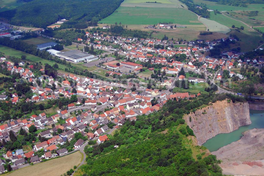 Altenglan / OT Rammelsbach from the bird's eye view: Blick über den Steinbruch auf die Gemeinde Rammelsbach. Rammelsbach ist eine Ortsgemeinde im Landkreis Kusel. Der Industrieort ist durch seinen 50 ha großen Melaphyrsteinbruch bekannt, in dem seit über 100 Jahren Hartsteine gewonnen und verarbeitet werden. Am oberen Bildrand ist die RME Manufacturing GmbH zu sehen. Die RME Manufacturing GmbH ist die deutsche Tochtergesellschaft der RITEK Corporation, dem weltweit führenden Produzenten digitaler Speichermedien. Kontakt: RME Manufacturing GmbH, Glanstr. 33, 66887 Rammelsbach, Tel.: 063814 260,