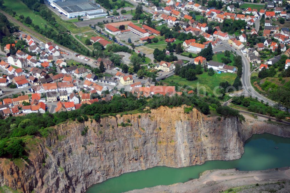 Aerial photograph Altenglan / OT Rammelsbach - Blick über den Steinbruch auf die Gemeinde Rammelsbach. Rammelsbach ist eine Ortsgemeinde im Landkreis Kusel. Der Industrieort ist durch seinen 50 ha großen Melaphyrsteinbruch bekannt, in dem seit über 100 Jahren Hartsteine gewonnen und verarbeitet werden. Am oberen Bildrand ist die RME Manufacturing GmbH zu sehen. Die RME Manufacturing GmbH ist die deutsche Tochtergesellschaft der RITEK Corporation, dem weltweit führenden Produzenten digitaler Speichermedien. Kontakt: RME Manufacturing GmbH, Glanstr. 33, 66887 Rammelsbach, Tel.: 063814 260,