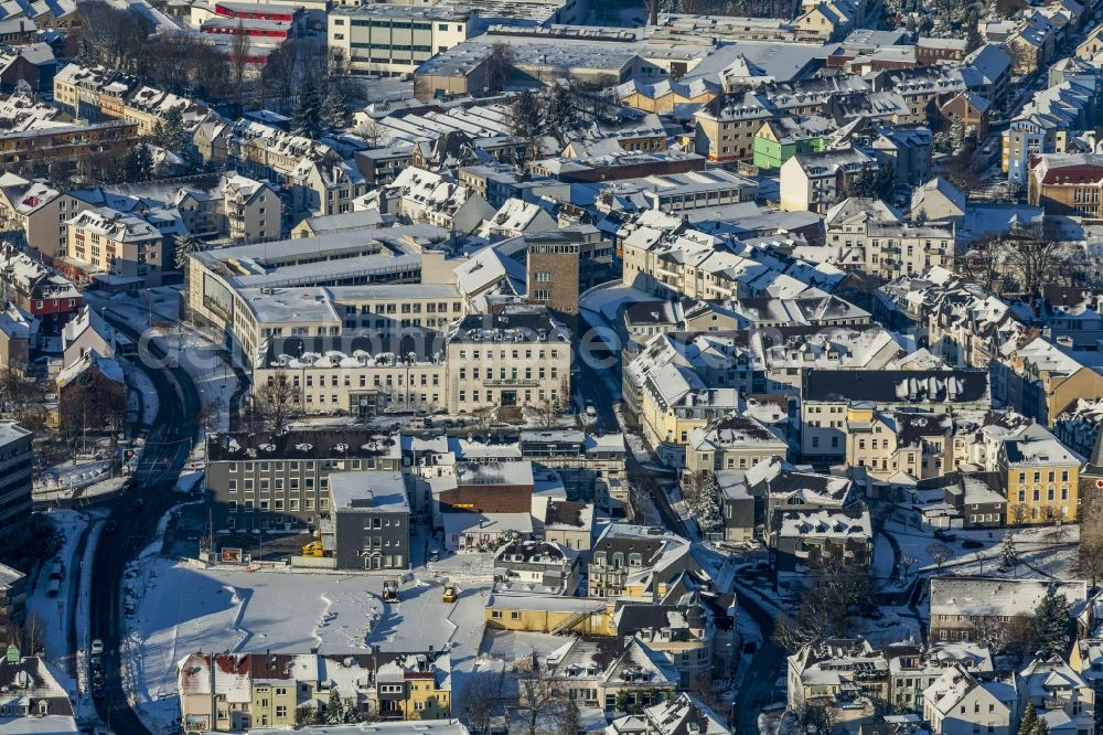 Velbert from the bird's eye view: Townscape and town hall of the winterly and snow-covered Velbert in the state of North Rhine-Westphalia. The town hall and administration building of Velbert includes a distinct brown tower and high rise. The building complex is located on Thomasstrasse in the North East of the town centre