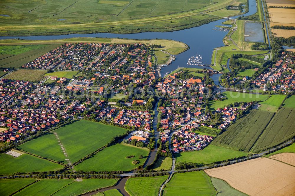 Aerial image Greetsiel - City view on the river bank Leyhoerner Sieltief - Silzufluss - Stoertebekerkanal on street Ant Hellinghus in Greetsiel in the state Lower Saxony, Germany