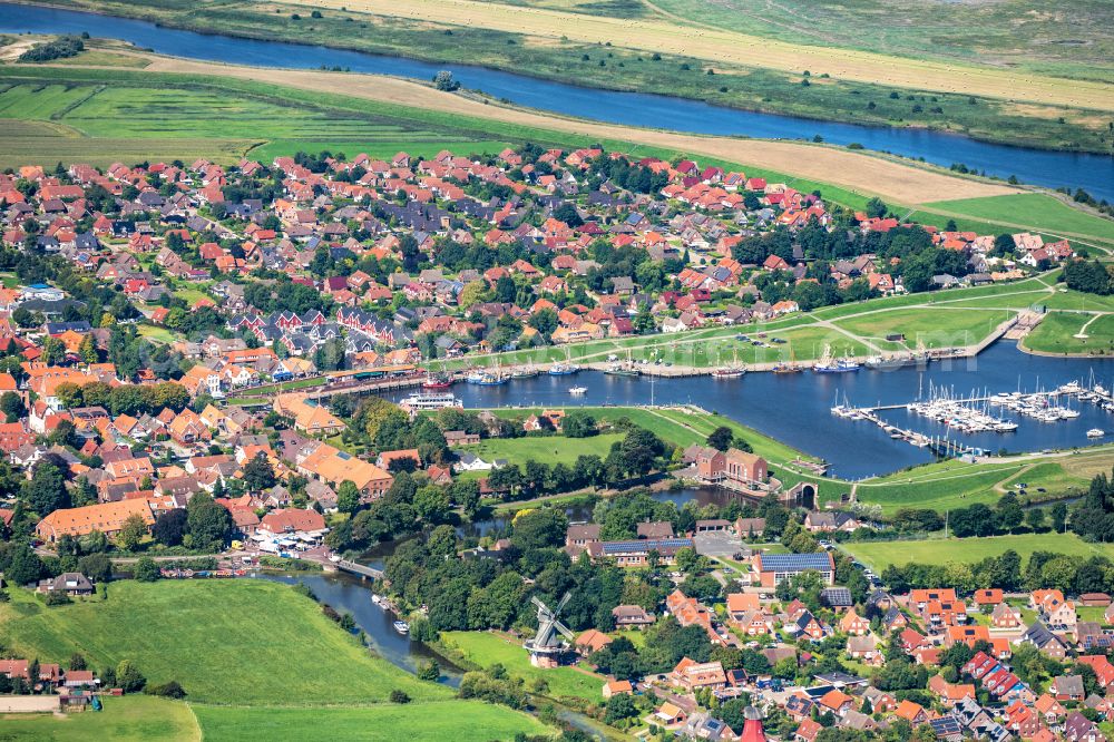 Aerial photograph Greetsiel - City view on the river bank Leyhoerner Sieltief - Silzufluss - Stoertebekerkanal on street Ant Hellinghus in Greetsiel in the state Lower Saxony, Germany